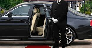 A luxury black car service and chauffeur waiting for guests, demonstrating seamless destination wedding transfers.