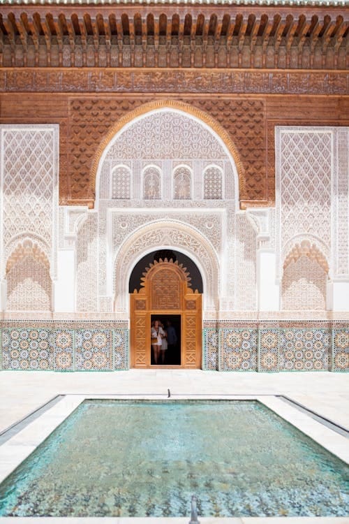 The ornate, mosaic-tiled entrance to a grand palace in Marrakech, Morocco, hinting at an opulent and culturally rich destination wedding venue.