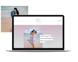 A laptop computer on a balcony table displays a wedding website, with a blurred background of a beautiful beach and ocean.