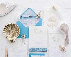 An elegant destination wedding invitation suite, including a Save the Date card and a passport, arranged neatly on a flat surface with tropical foliage.